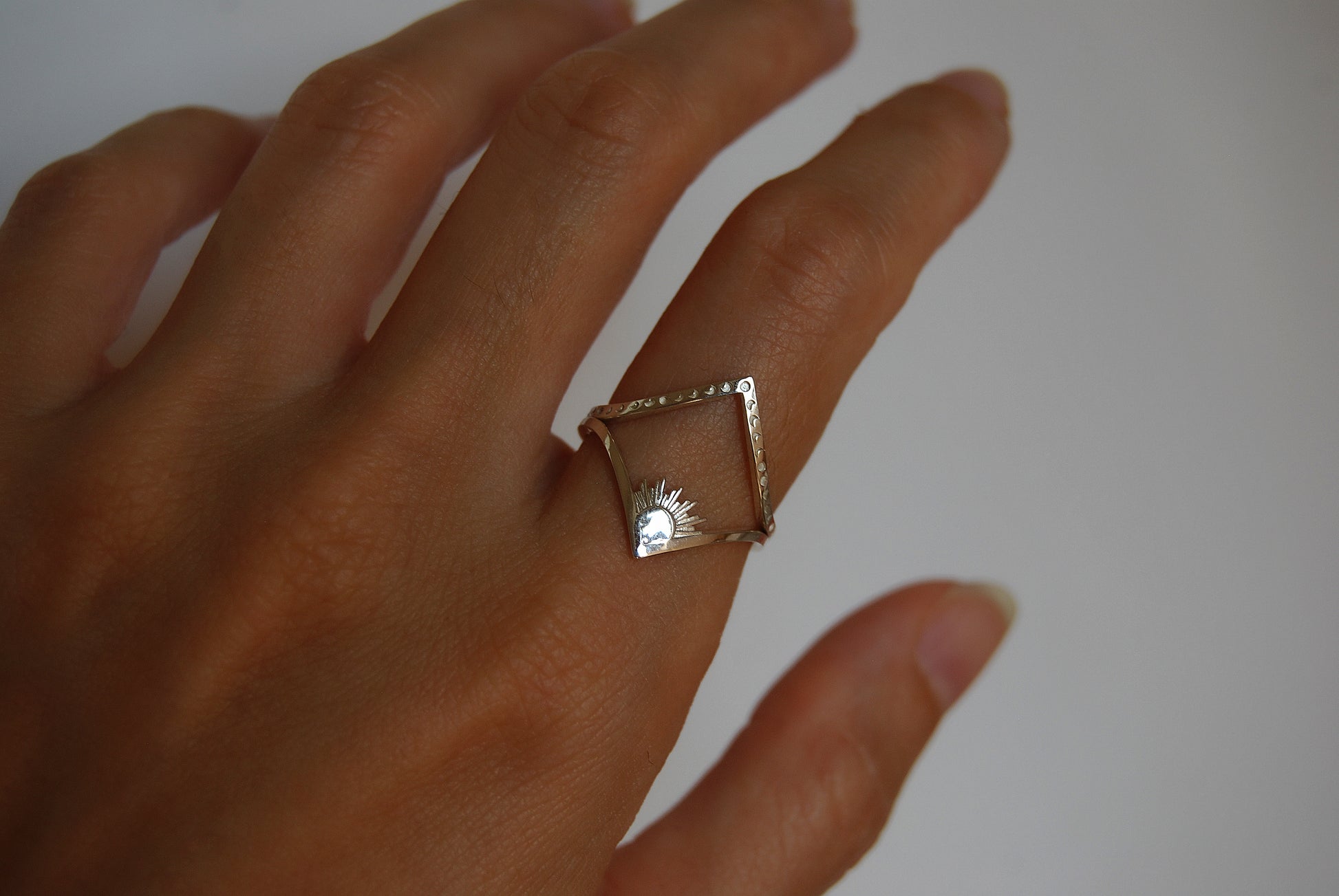 Sun and moon chevron rings stacked together, highlighting minimalist celestial jewelry design.