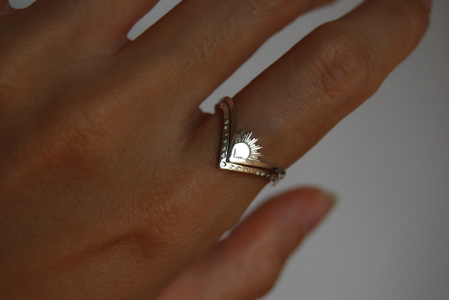 Sun and moon chevron rings stacked in opposite directions, emphasizing cosmic duality in celestial jewelry.