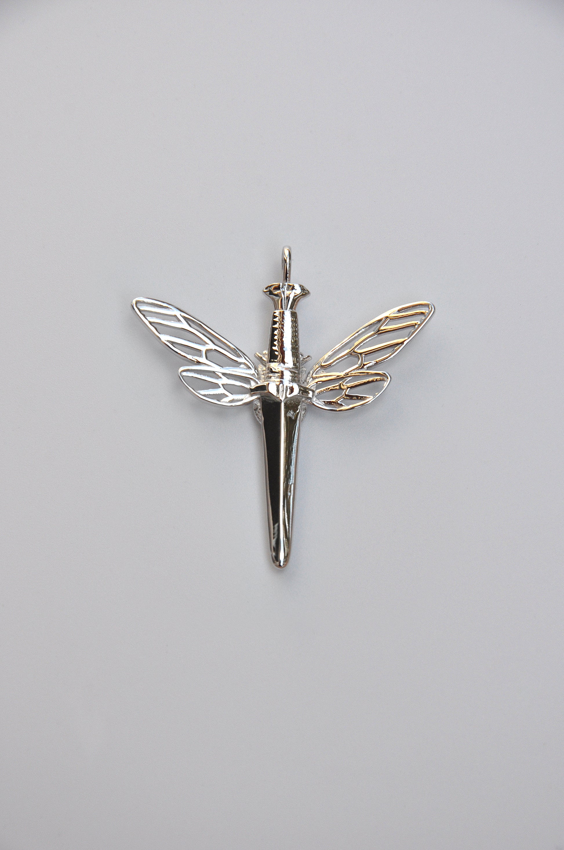 Symbolic cicada dagger pendant in 925 sterling silver with luminous white stone, blending nature and strength.