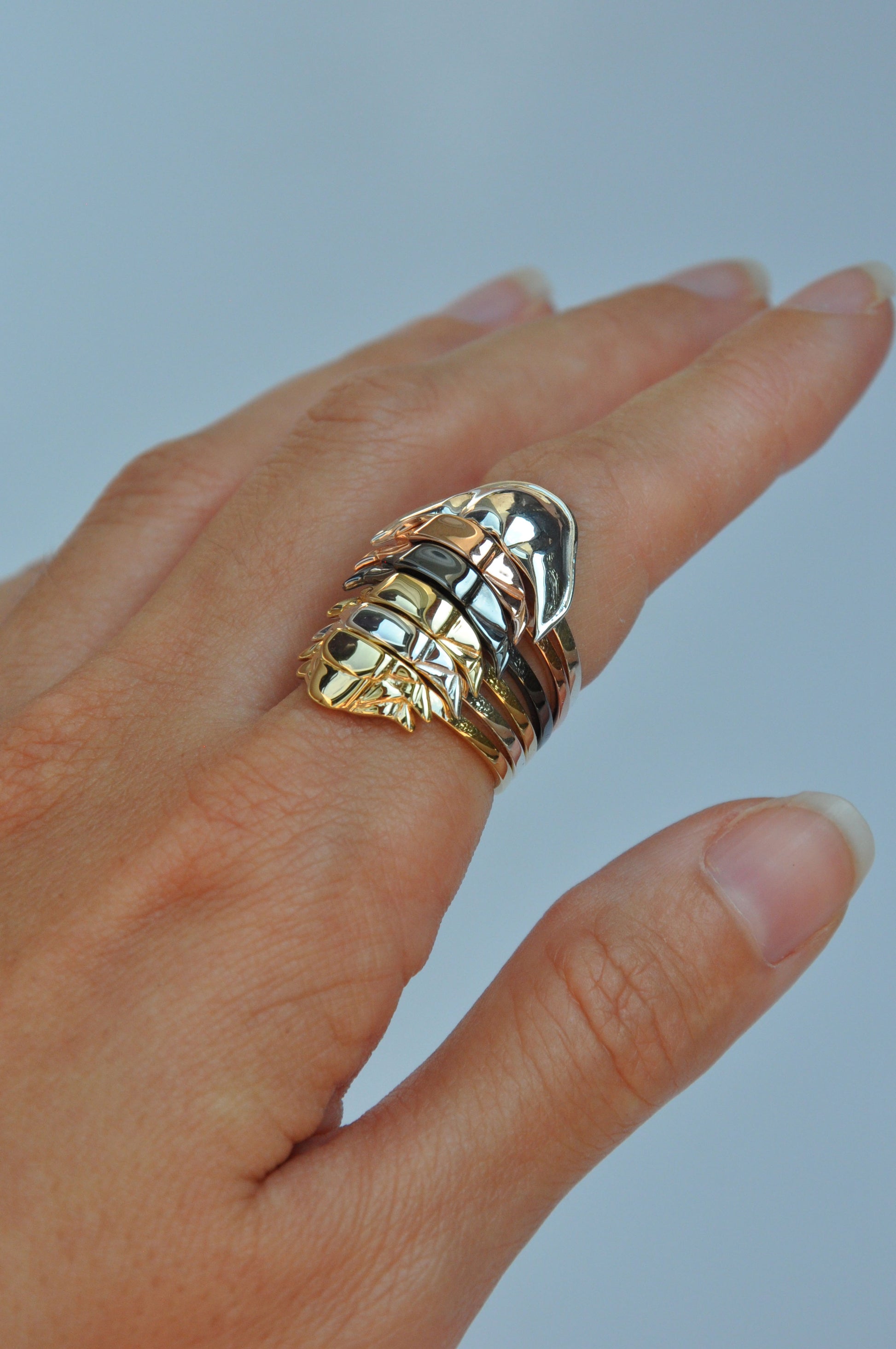 Side angle of handcrafted fossil rings with mixed metal plating – artisan trilobite rings for stacking gemstone band lovers.