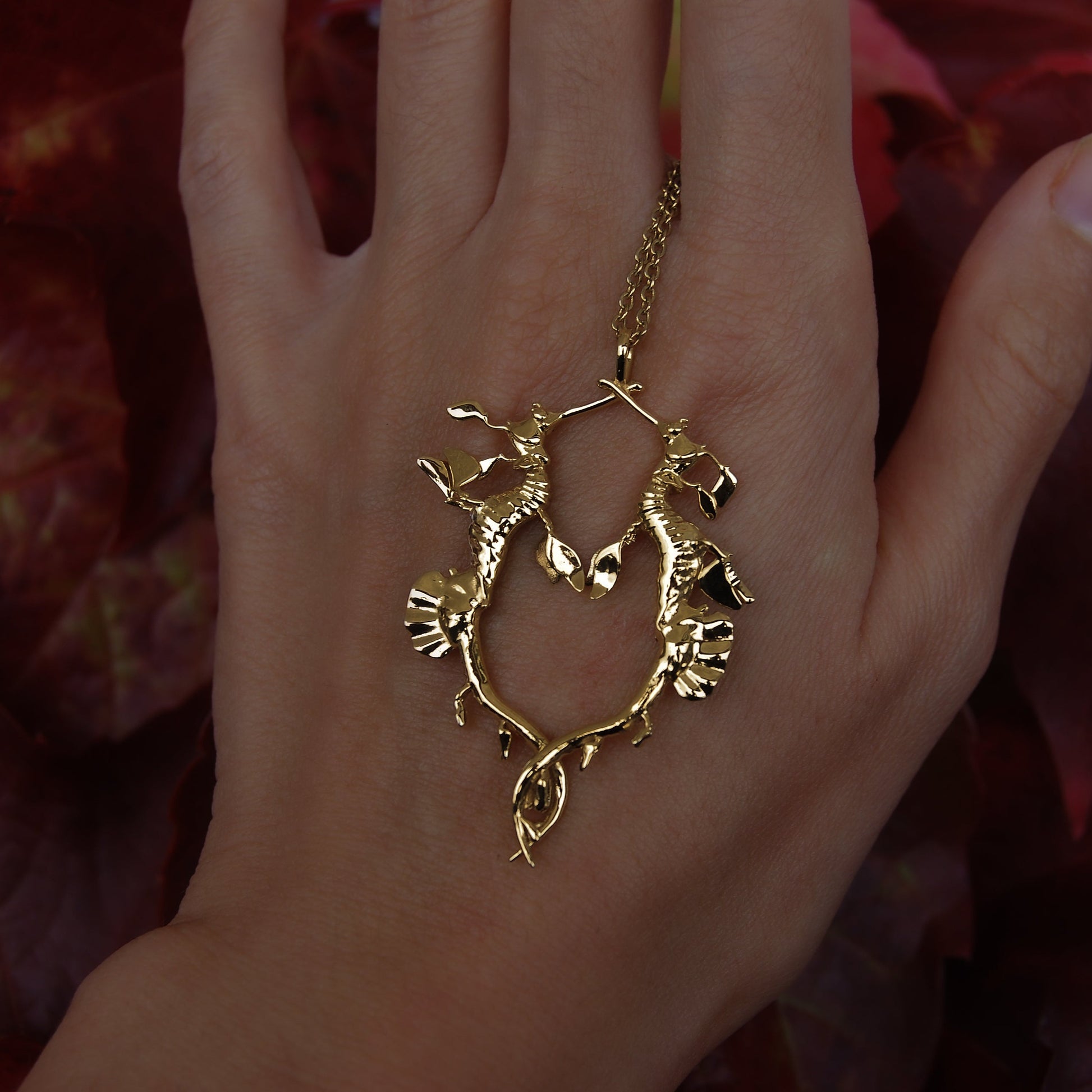 Gold Weedy Sea Dragon Pendant worn on hand, showing scale and delicate craftsmanship.