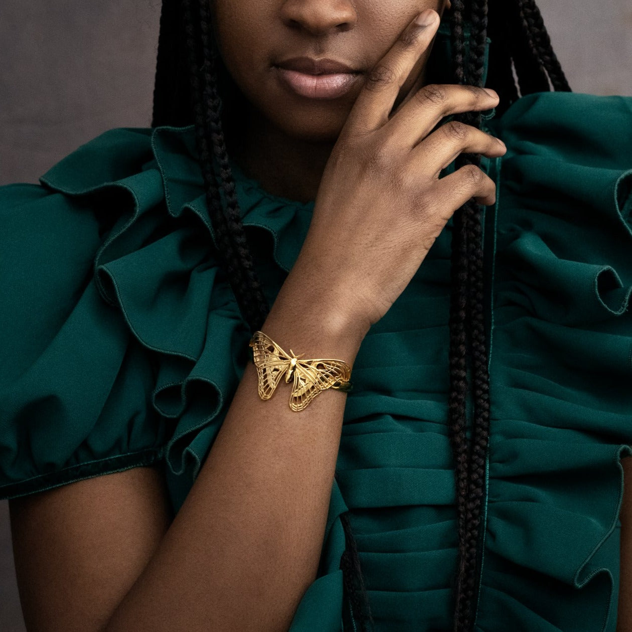 Model wearing the Atlas Moth Bracelet in 14k gold-plated brass. The sculptural moth design wraps elegantly around the wrist, catching warm light and showcasing its intricate wing details. Styled in a natural setting, the bracelet evokes a sense of organic beauty and timeless craftsmanship.