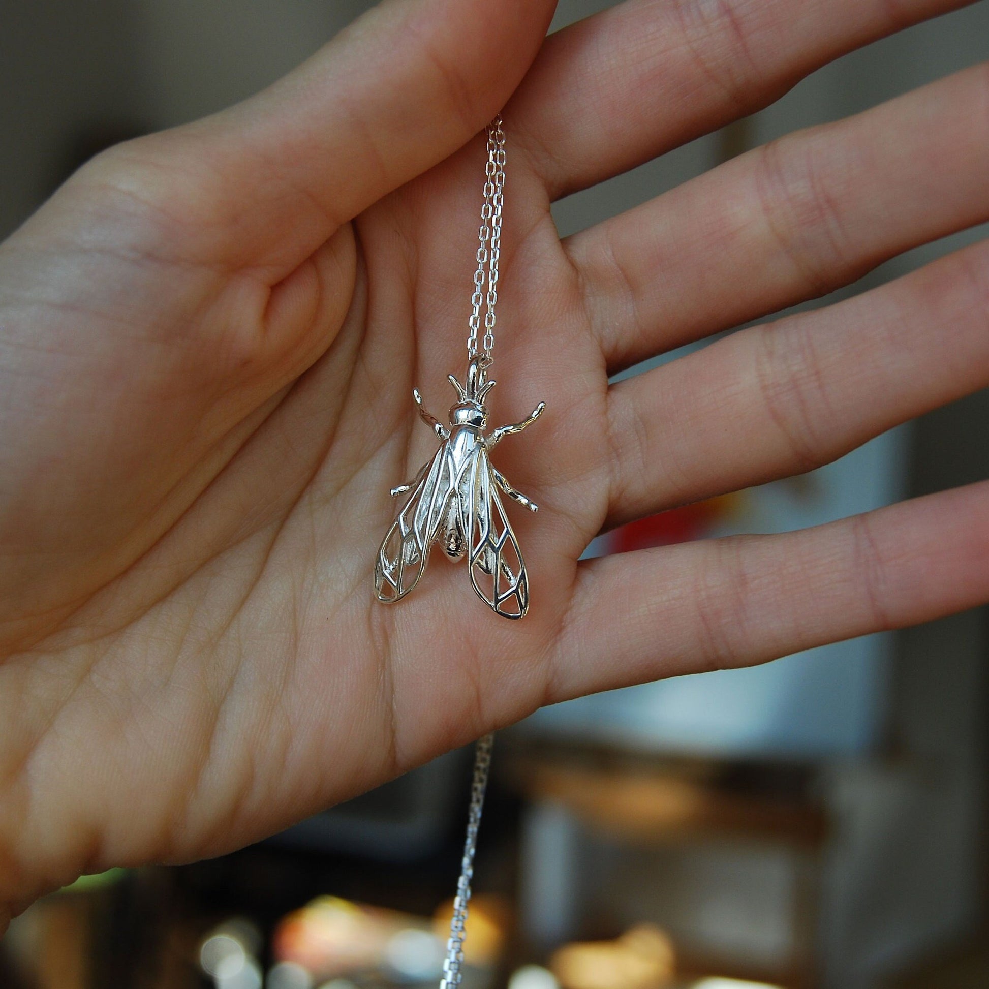 Sterling silver wasp pendant worn on hand, showcasing intricate insect details2